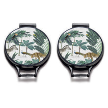 Load image into Gallery viewer, Set of two. darwin's menagerie tropical print with palms, peacock, zebra, leopard painting on a beige linen circular aga cover with black hemming. Pictured on metal aga lid on an isolated background. Mustard and Gray