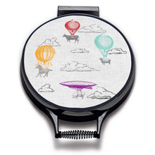 Load image into Gallery viewer, Farm High Life cow, sheep, horse and pig sketch drawings with colourful hot air balloons print on a beige linen circular aga cover with black hemming. Pictured on metal aga lid on an isolated background. Mustard and Gray