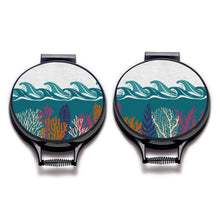 Load image into Gallery viewer, Set of two colourful terquoise waves and pink and orange seaweed print on a beige linen circular aga cover with black hemming. Pictured on metal aga lid on an isolated background. Mustard and Gray