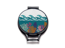 Load image into Gallery viewer, colourful terquoise waves and pink and orange seaweed print on a beige linen circular aga cover with black hemming. Pictured on metal aga lid on an isolated background. Mustard and Gray