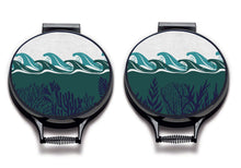 Load image into Gallery viewer, Set of two colourful green waves and navy seaweed print on a beige linen circular aga cover with black hemming. Pictured on metal aga lid on an isolated background. Mustard and Gray