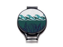 Load image into Gallery viewer, colourful green waves and navy seaweed print on a beige linen circular aga cover with black hemming. Pictured on metal aga lid on an isolated background. Mustard and Gray