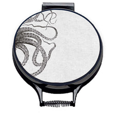 Load image into Gallery viewer, black kraken squid octocpus tenticles print on a beige linen circular aga cover with black hemming. Pictured on metal aga lid on an isolated background. Mustard and Gray