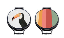 Load image into Gallery viewer, Set of two hob covers. Toco Toucan illustration print on a beige linen circular aga cover with black hemming. Stripes of Green, red, Pink and orange on one aga chef&#39;s pad and fish tail of the other aga chef&#39;s pad. Pictured on metal aga lid on an isolated background. Mustard and Gray
