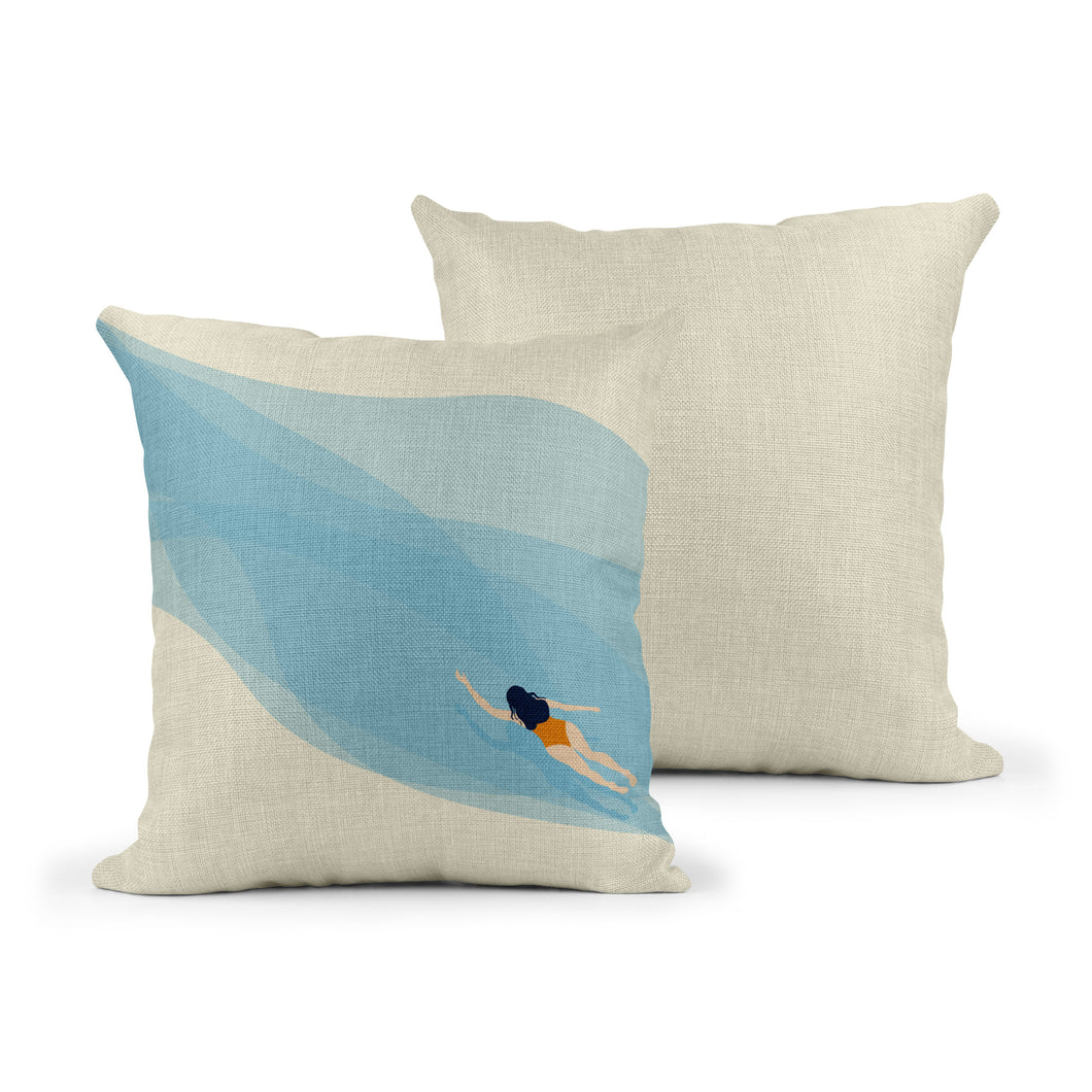 Image of the front and back of a linen effect cushion. On the front there is a swirling blue background going diagonally over the cusion with a simple illustration of a swimmer in an orange coostume.