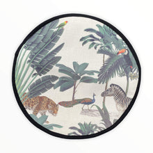 Load image into Gallery viewer, darwin&#39;s menagerie tropical print with palms, peacock, zebra, leopard painting on a beige linen circular aga cover with black hemming. Mustard and Gray
